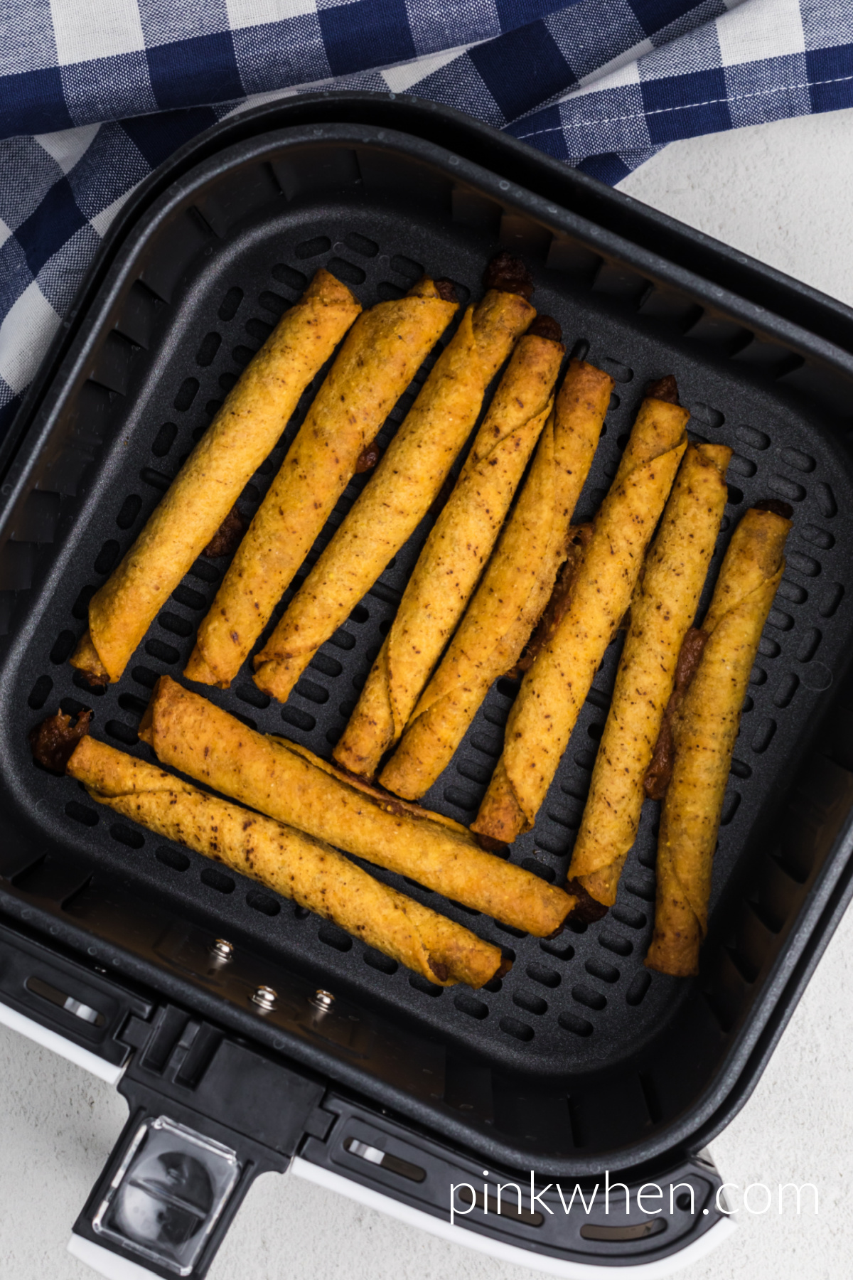 Air Fryer Frozen Taquitos fully cooked in the basket of the air fryer. 