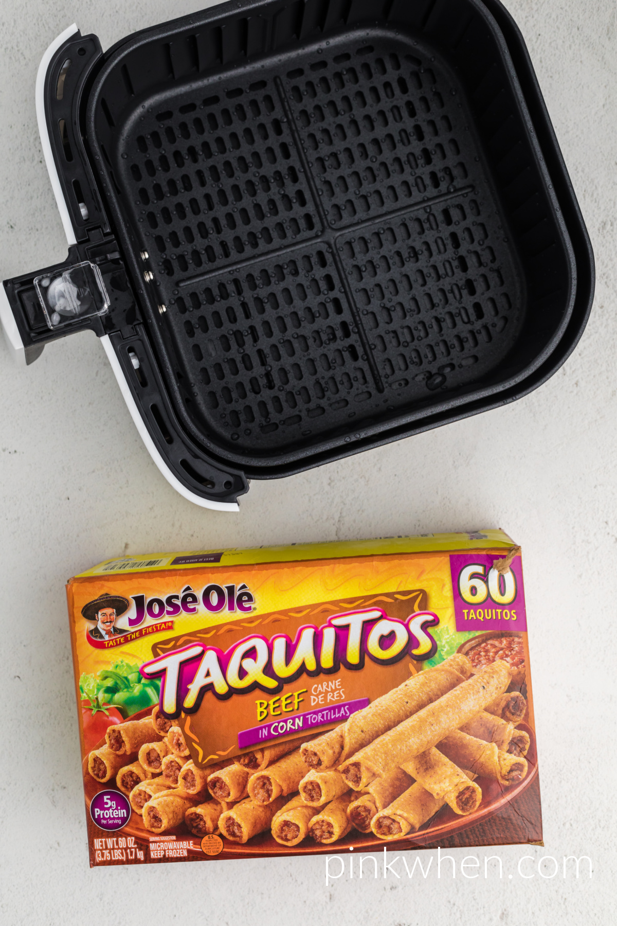 Basket of the air fryer and a box of frozen taquitos.