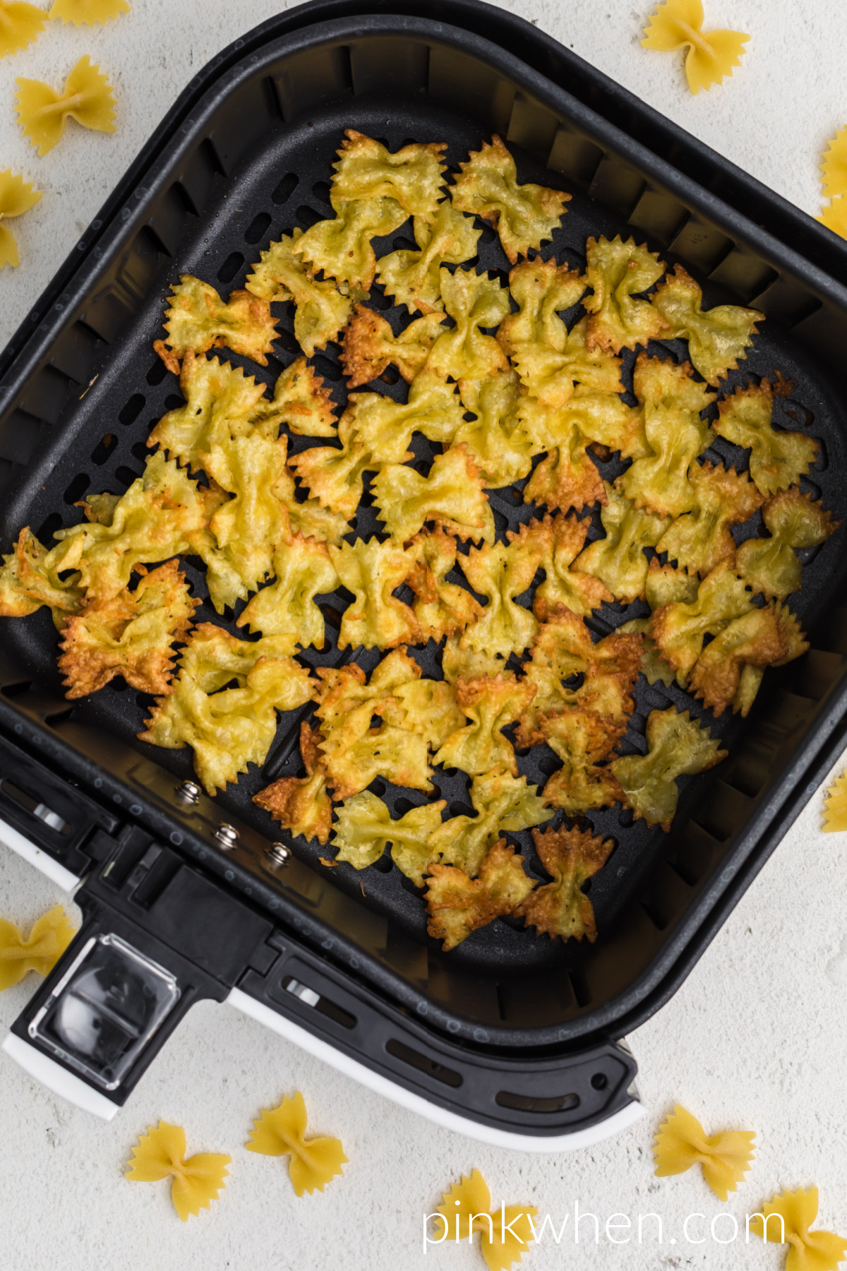 Air Fried pasta chips in the basket of the air fryer. 