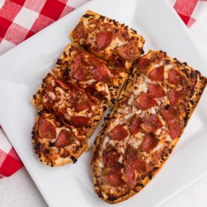 french bread pizzas made in the air fryer on a white plate.