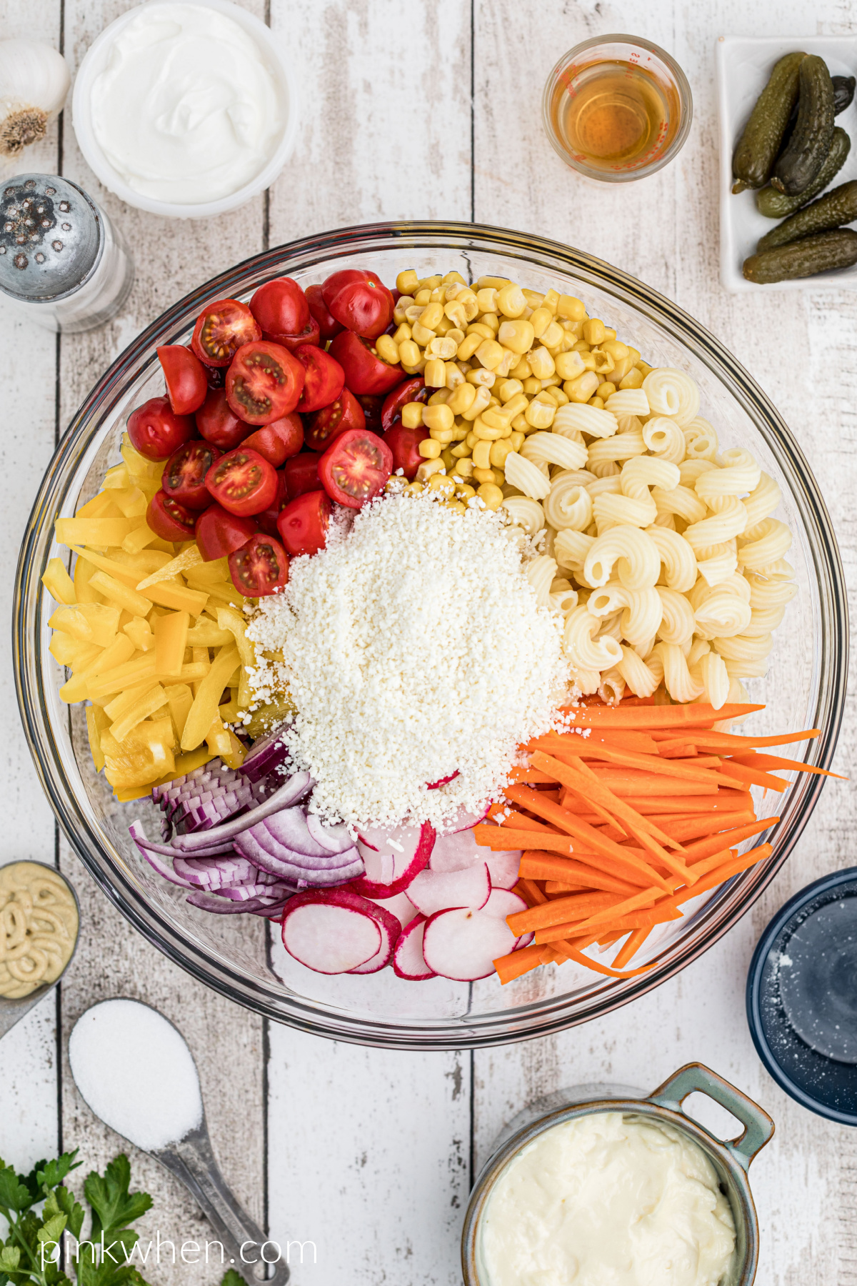 Ingredients for a summer pasta salad added to a large mixing bowl.