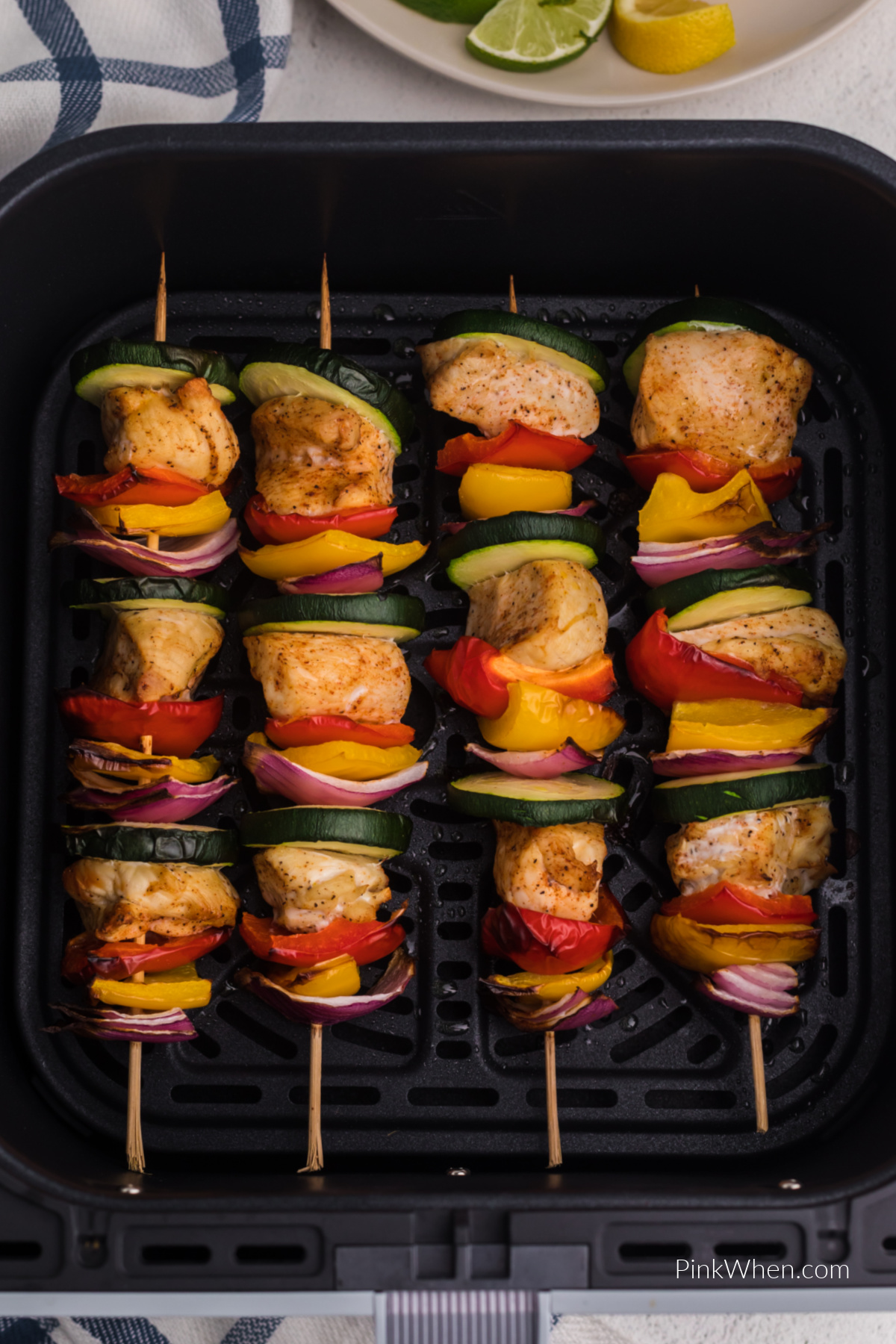 Air fried chicken kabobs in the basket of the air fryer. 