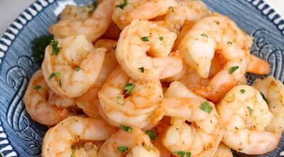 Orange shrimp on a blue plate in front of an instant pot