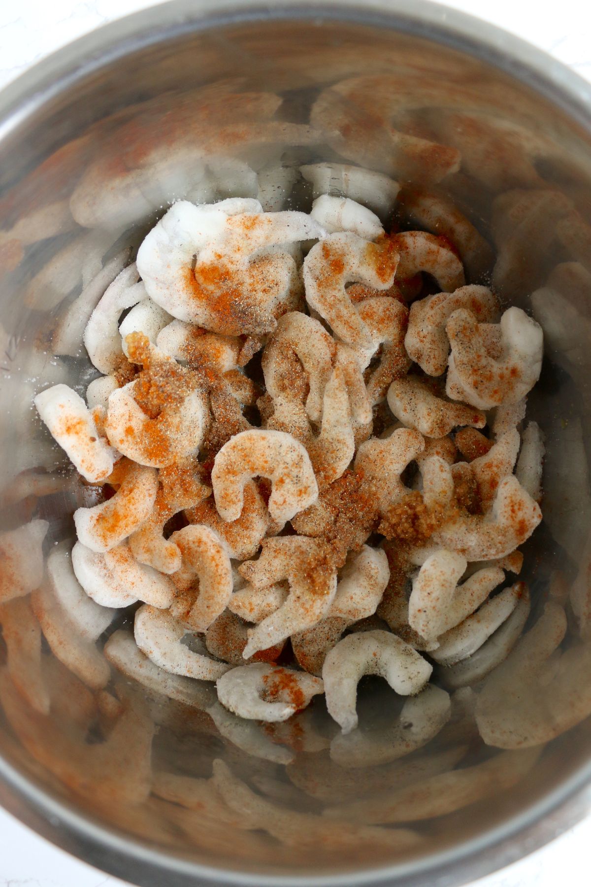 Frozen shrimp seasoned in the instant pot before being cooked.