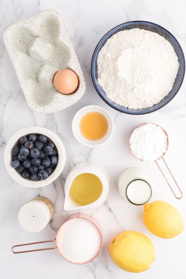 Ingredients measured on a white marble table before making muffin batter