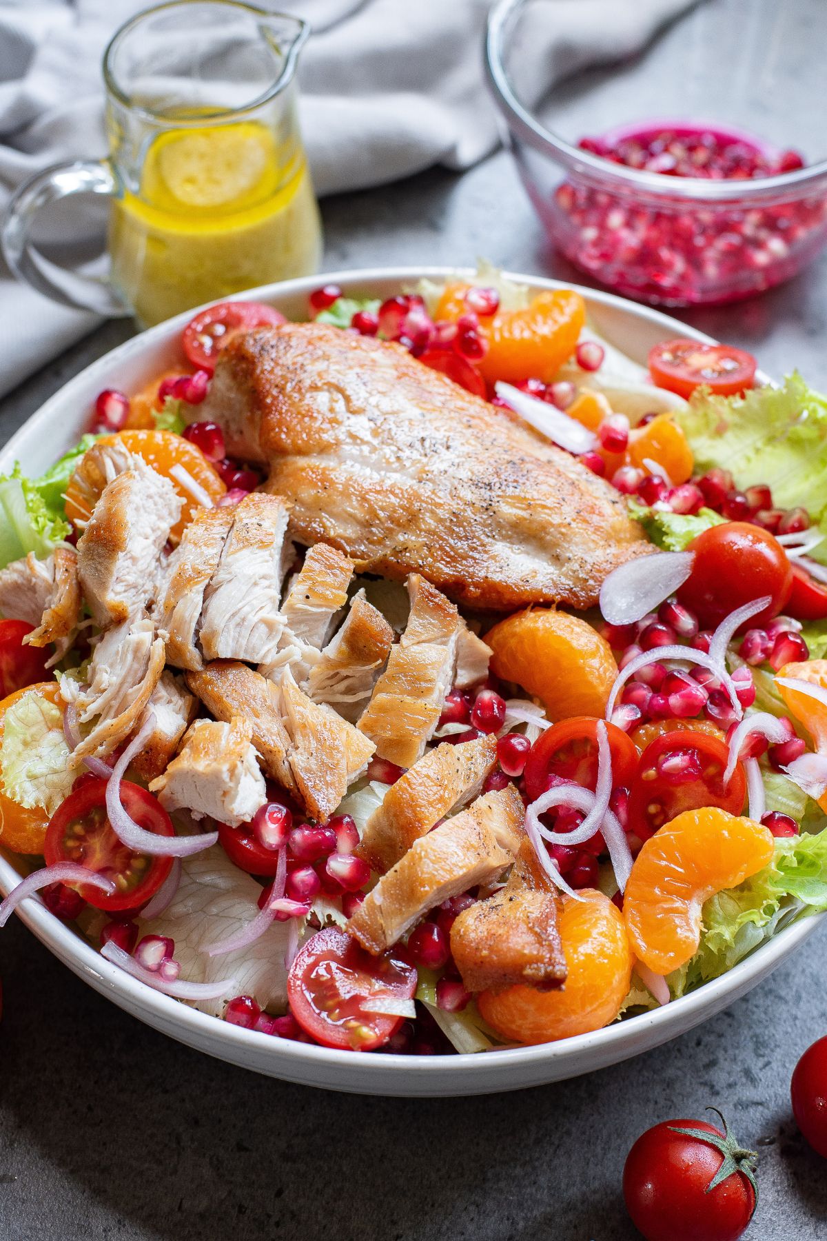 Cooked chicken on top of a salad, being cut into slices. 