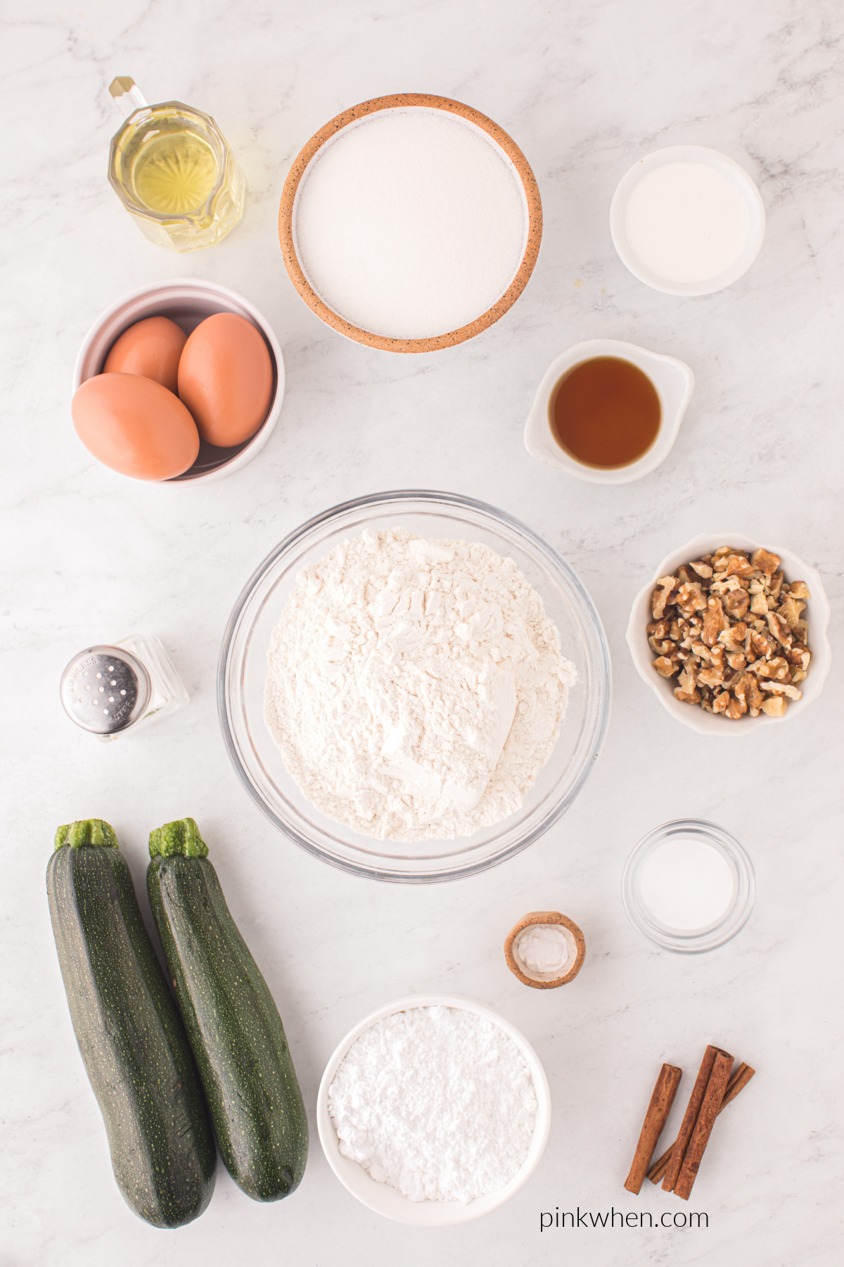 Ingredients in bowls on a table that are used to make zucchini bundt cake with cinnamon icing.