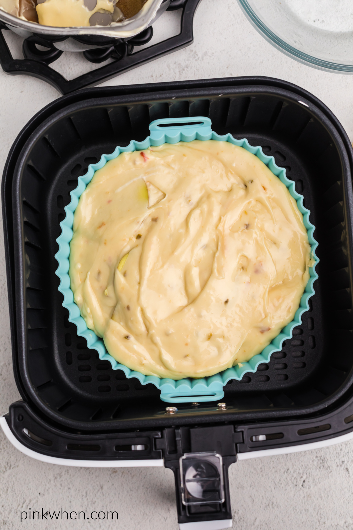 Cheesy scalloped potatoes in the basket of the air fryer.