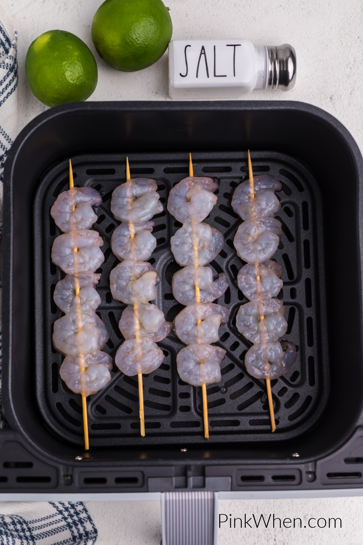 Shrimp skewers in the air fryer basket ready to cook.