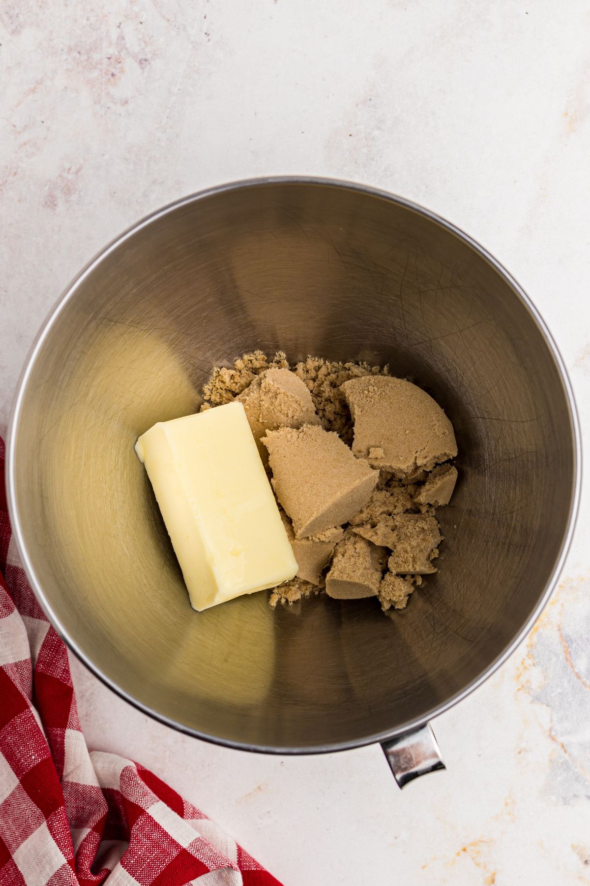 Butter and brown sugar being added to a mixing bowl