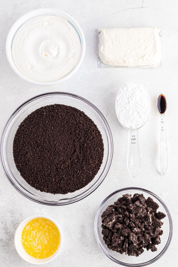 Ingredients needed to make Oreo pie measured on a white marble table. 