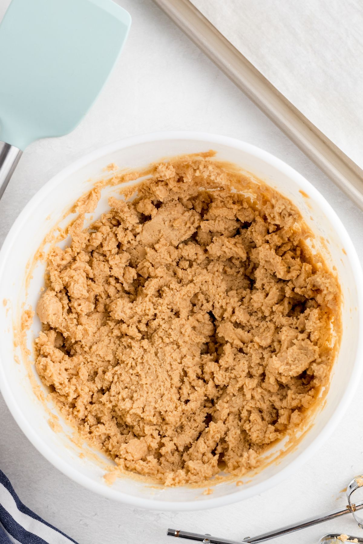 Golden fluffy cookie dough in a white mixing bowl