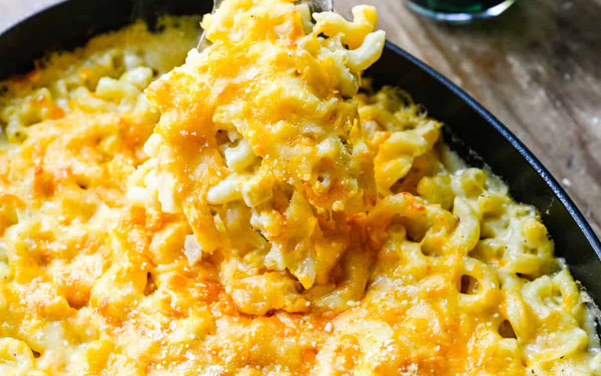 Baked mac and cheese with spoonful in a casserole dish.