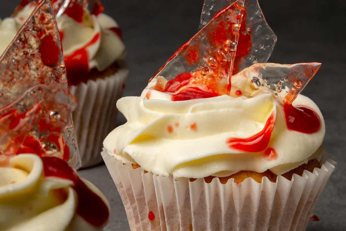 Halloween cupcakes with red decorations on top.