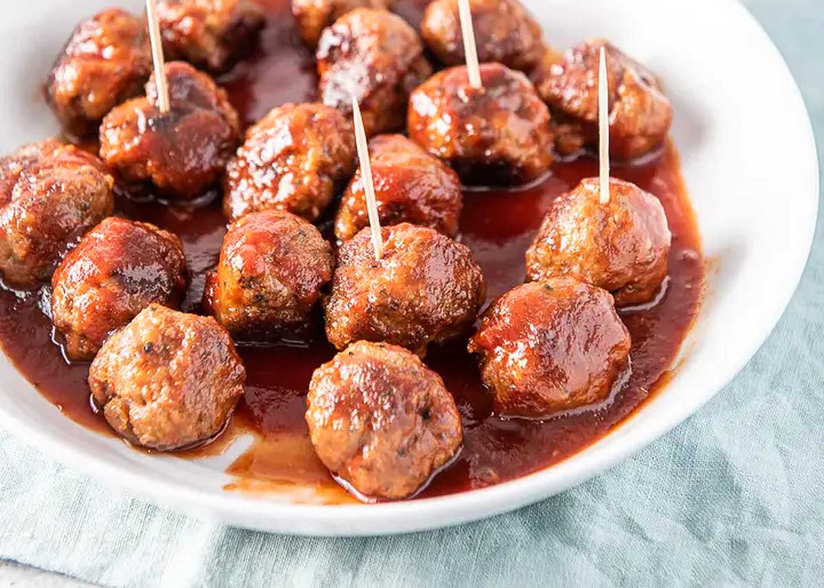 A dish with meatballs with toothpicks in them.