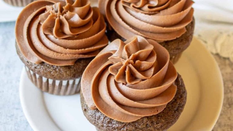 Three chocolate cupcakes on a white plate.