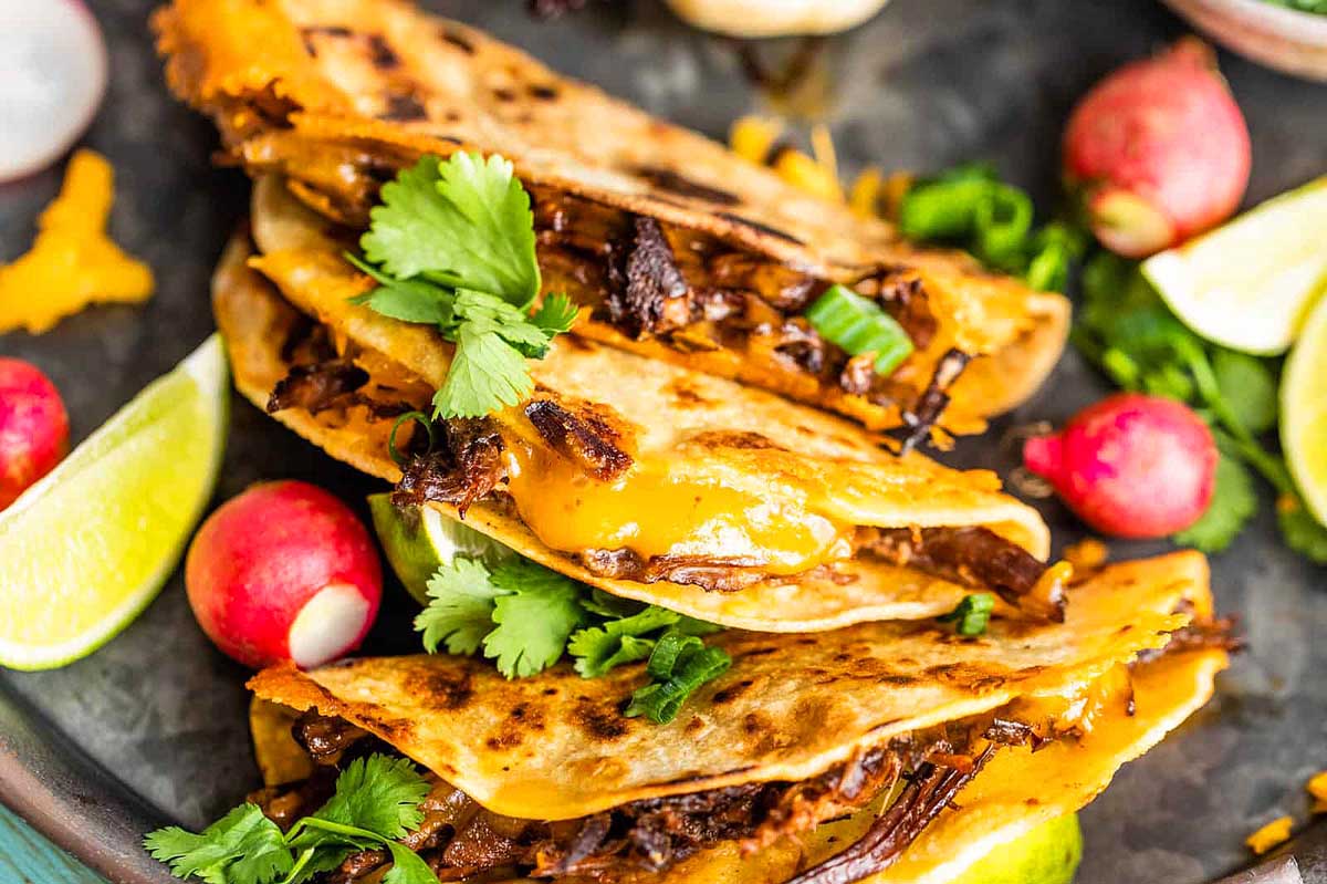 Mexican beef quesadillas on a black plate.
