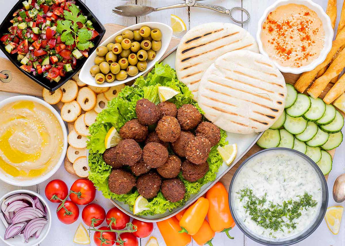 A plate of falafel with various dip sides.