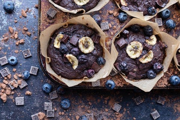 Double chocolate blueberry banana muffins in muffin tins.