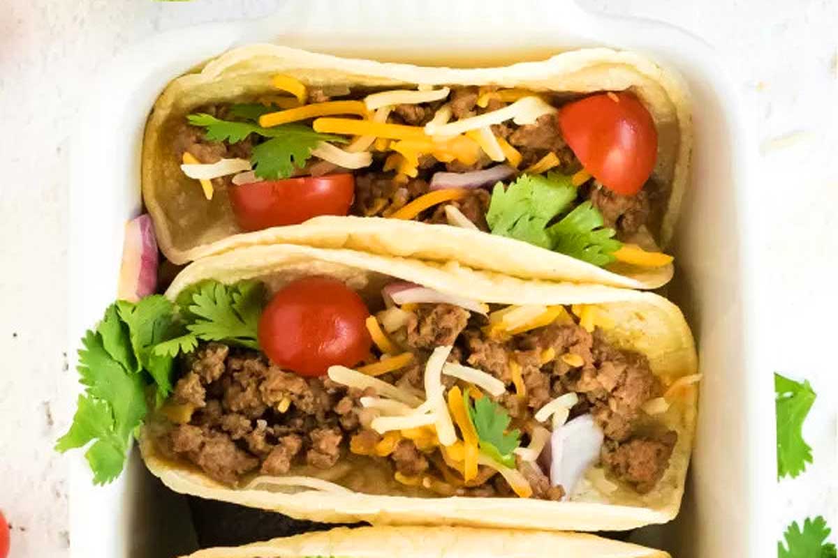 Beef tacos in a white baking dish.