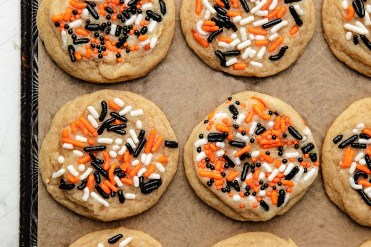 A baking sheet of sugar cookies with festive Halloween sprinkles.