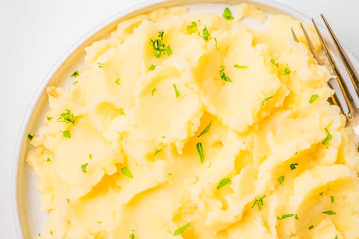 Creamy mashed potatoes with fresh herbs on top.