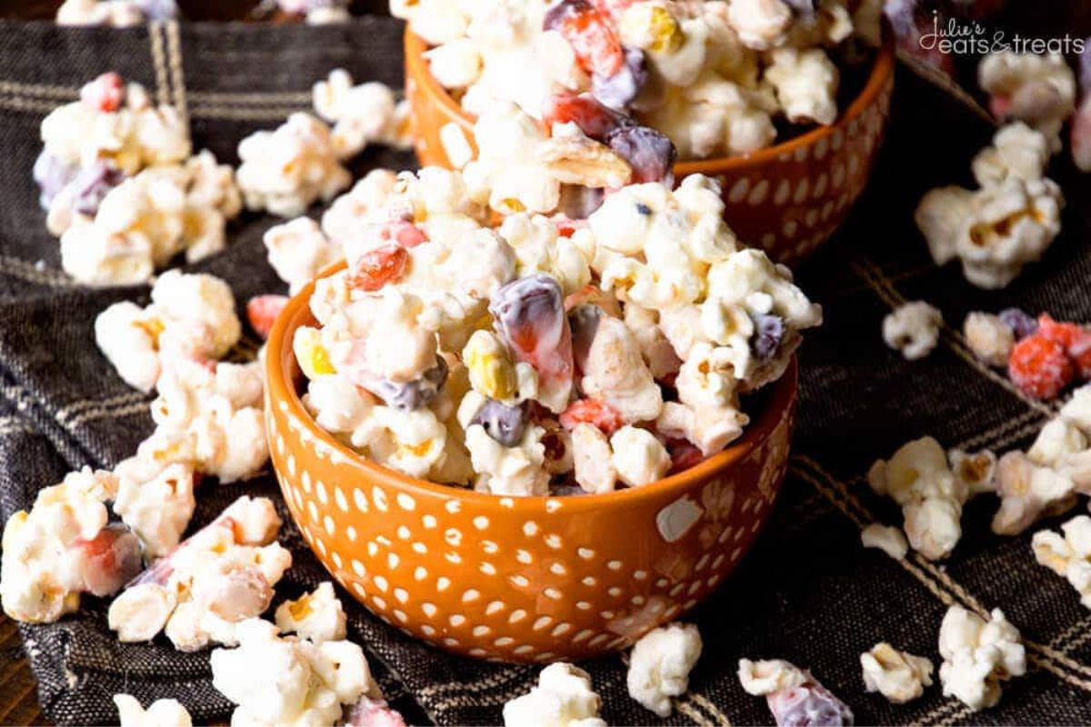Bowls of white chocolate coated popcorn with candy.
