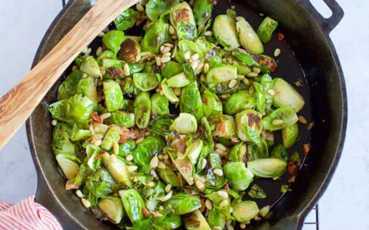 Sauteed brussels sprouts in a cast iron pan.