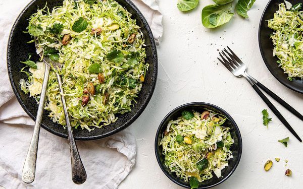 Shaved brussels sporuts salad in two bowls.