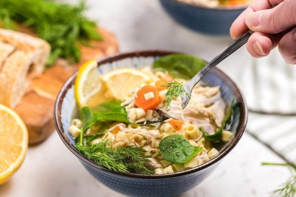 Slow Cooker Greek Lemon Chicken Soup with herbs and vegetables.