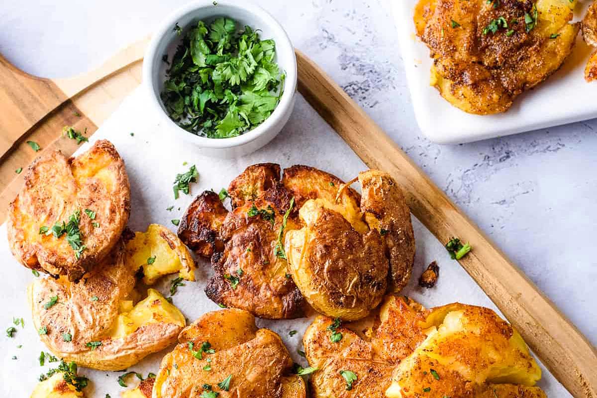 Crispy Garlic Smashed Potatoes on a plate with dip.