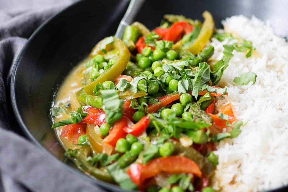 A green curry made with peas, and peppers served over rice.