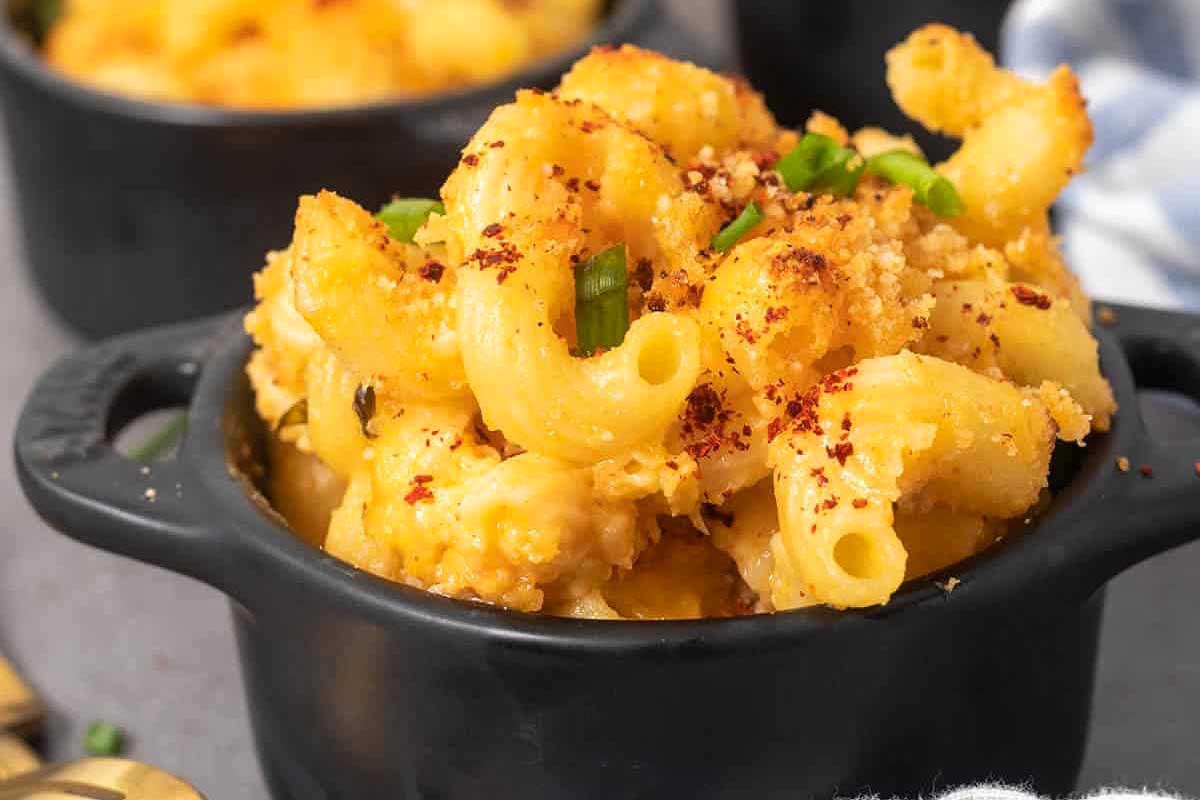 Mac and cheese with kimchi in little black ramekins.