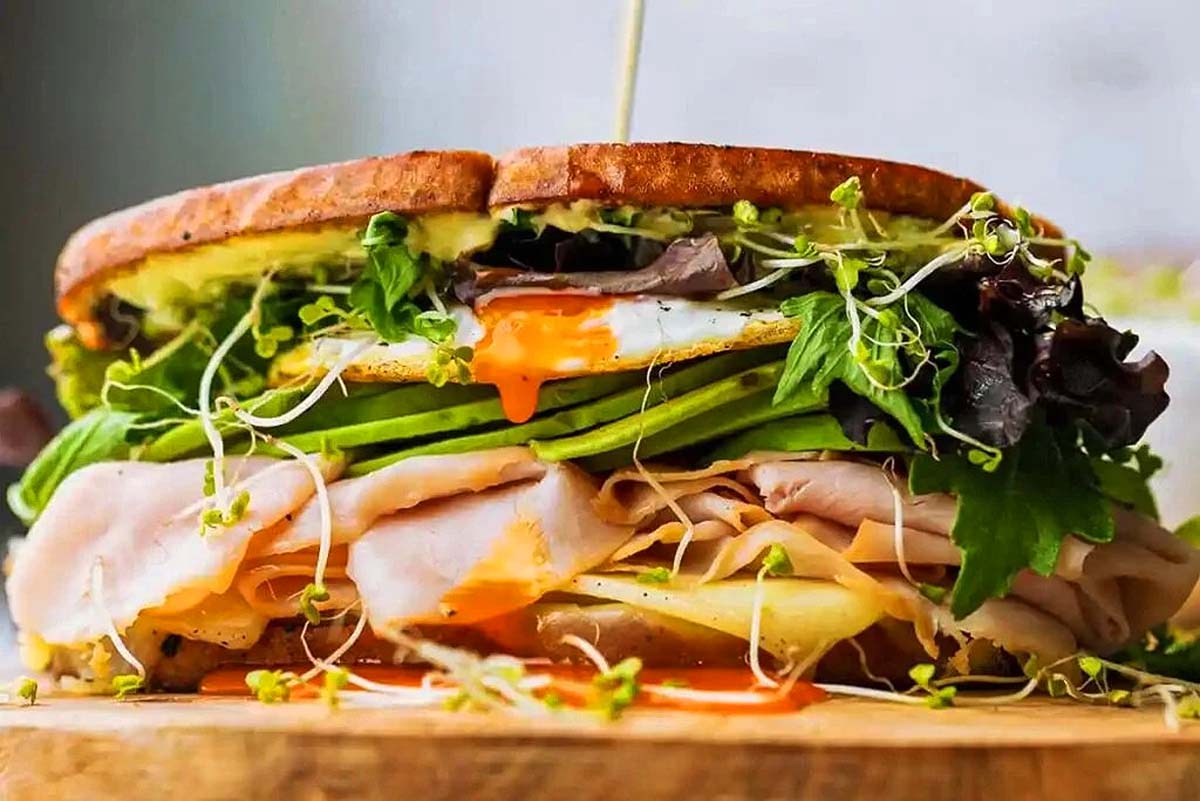 A thick turkey sandwich with lots of toppings.