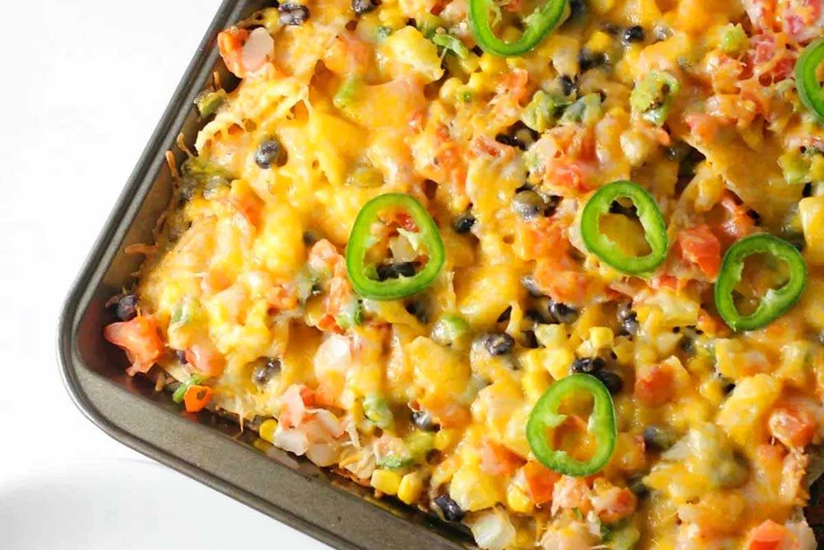 Colorful chicken nachos with cheese and toppings.