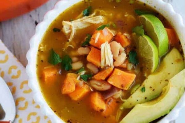 White Chicken Chili with Sweet Potatoess and avocado served in a bwl.