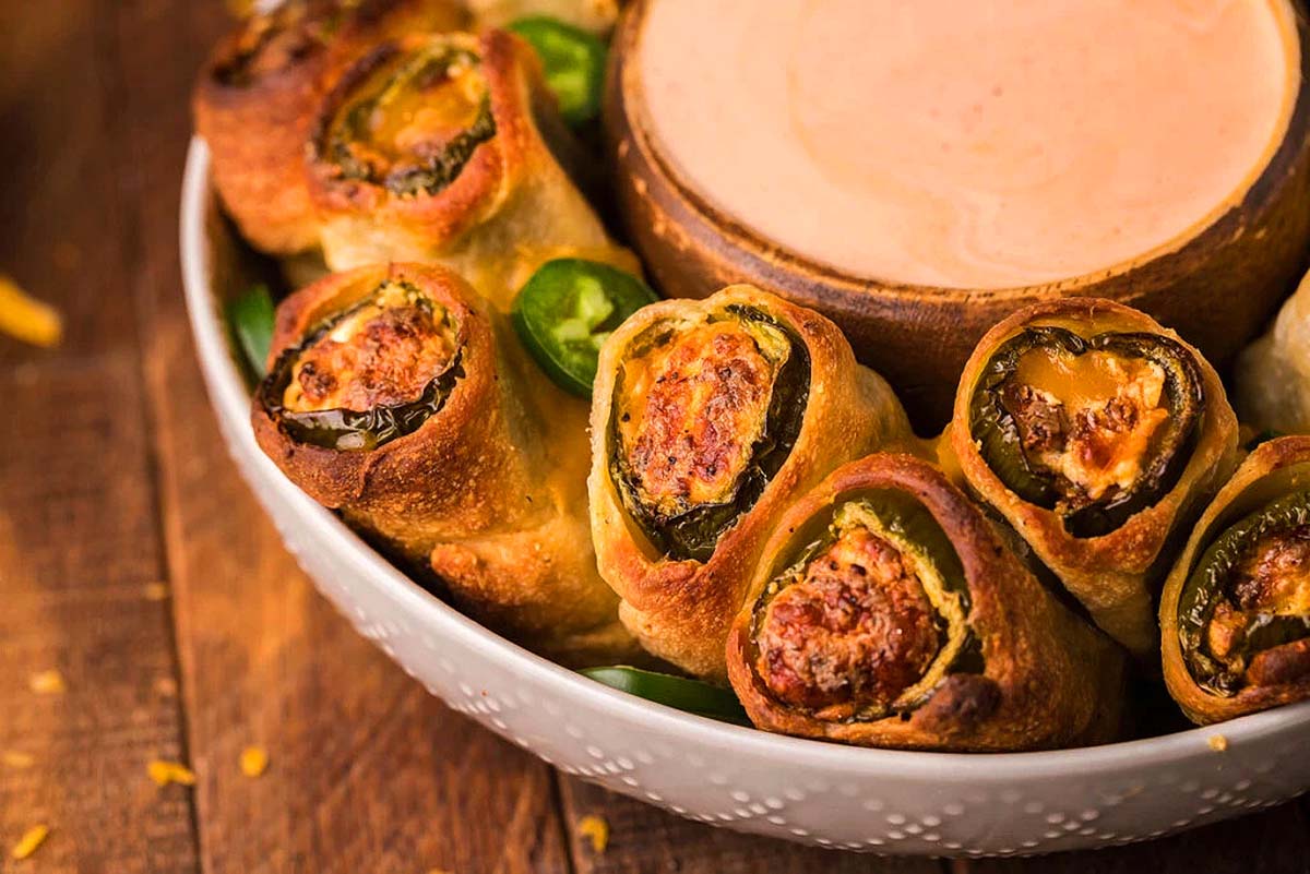 Air fried jalapeno popper rolls on a plate with a bowl of dip. The best air fryer recipes.
