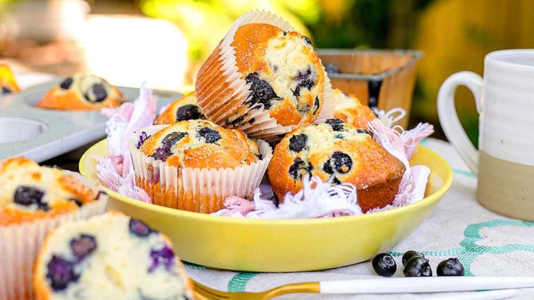 Blueberry muffins and a cup of coffee in a yellow bowl.