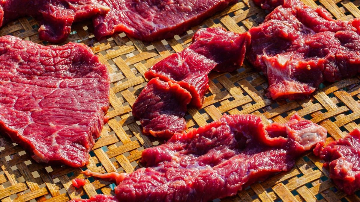 Sun-dried beef sliced and put on stainless tray then dried with the sunlight. Traditional Thai food preservation.