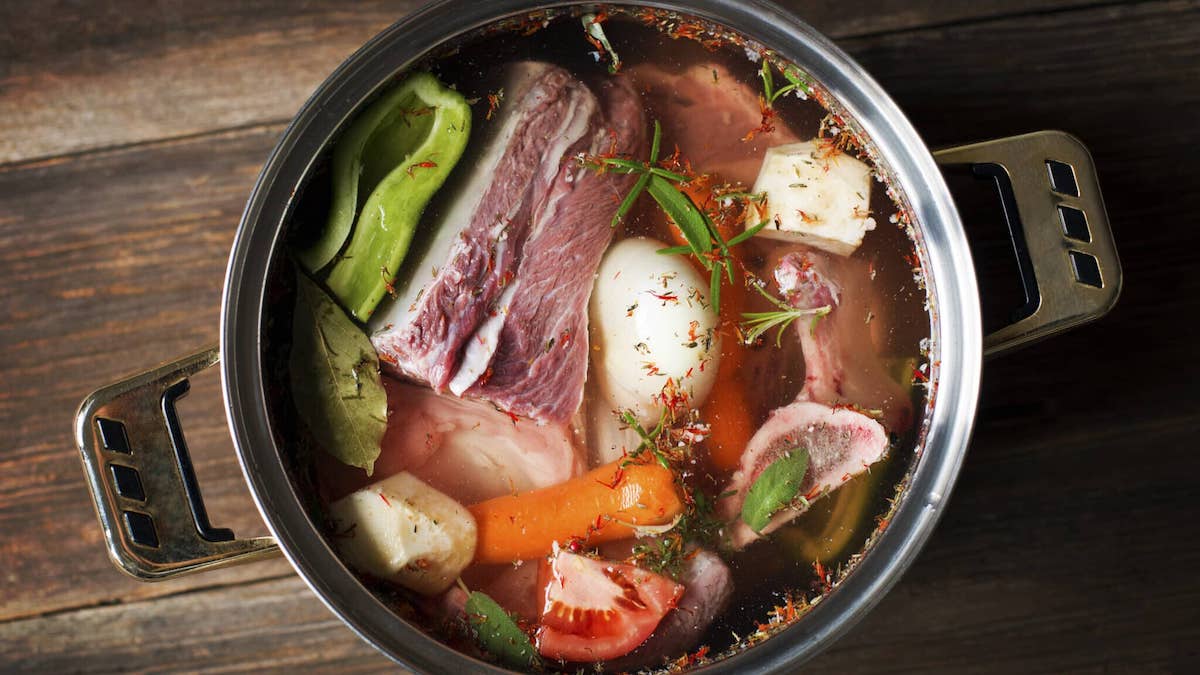 Fresh beef soup ingredients in large pot.