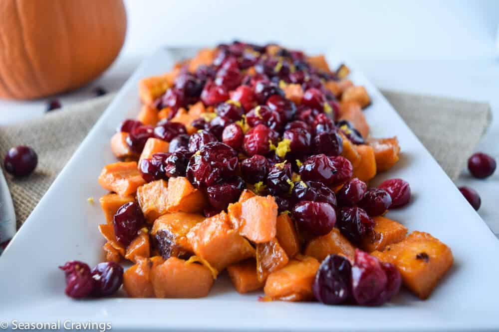 sweet potatoes and cranberries on a white tray.