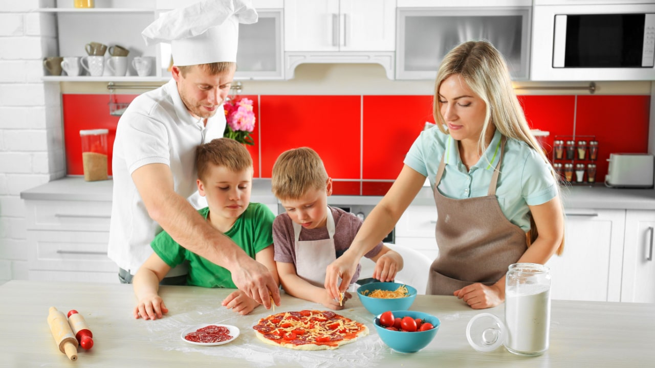 Happy family making pizza in kitchen.