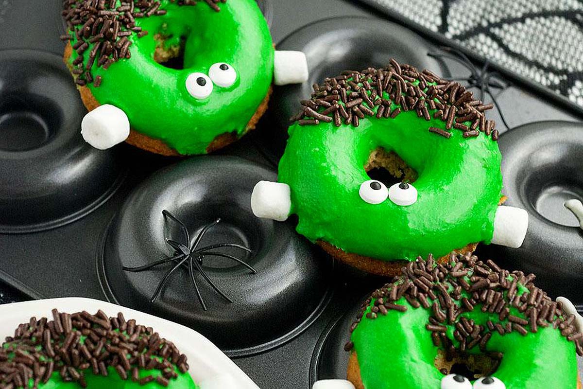 Donuts decorated to look like Frankenstein with green icing and sprinkles.