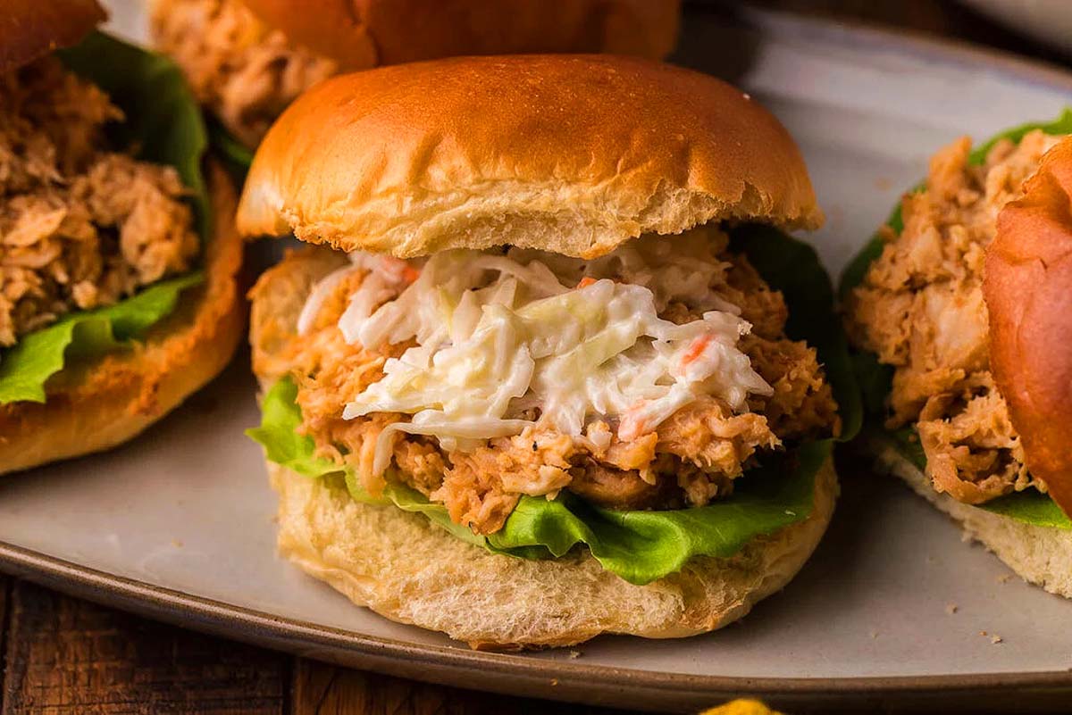 A pulled chicken sandwich coleslaw and lettuce.