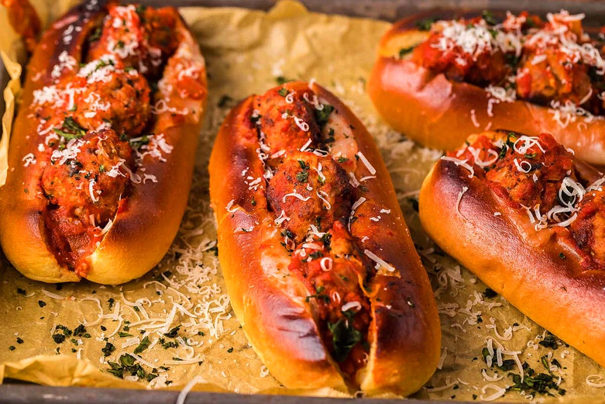 Meatball subs are  in toasted buns on a tray. The Best easy dinner recipes.