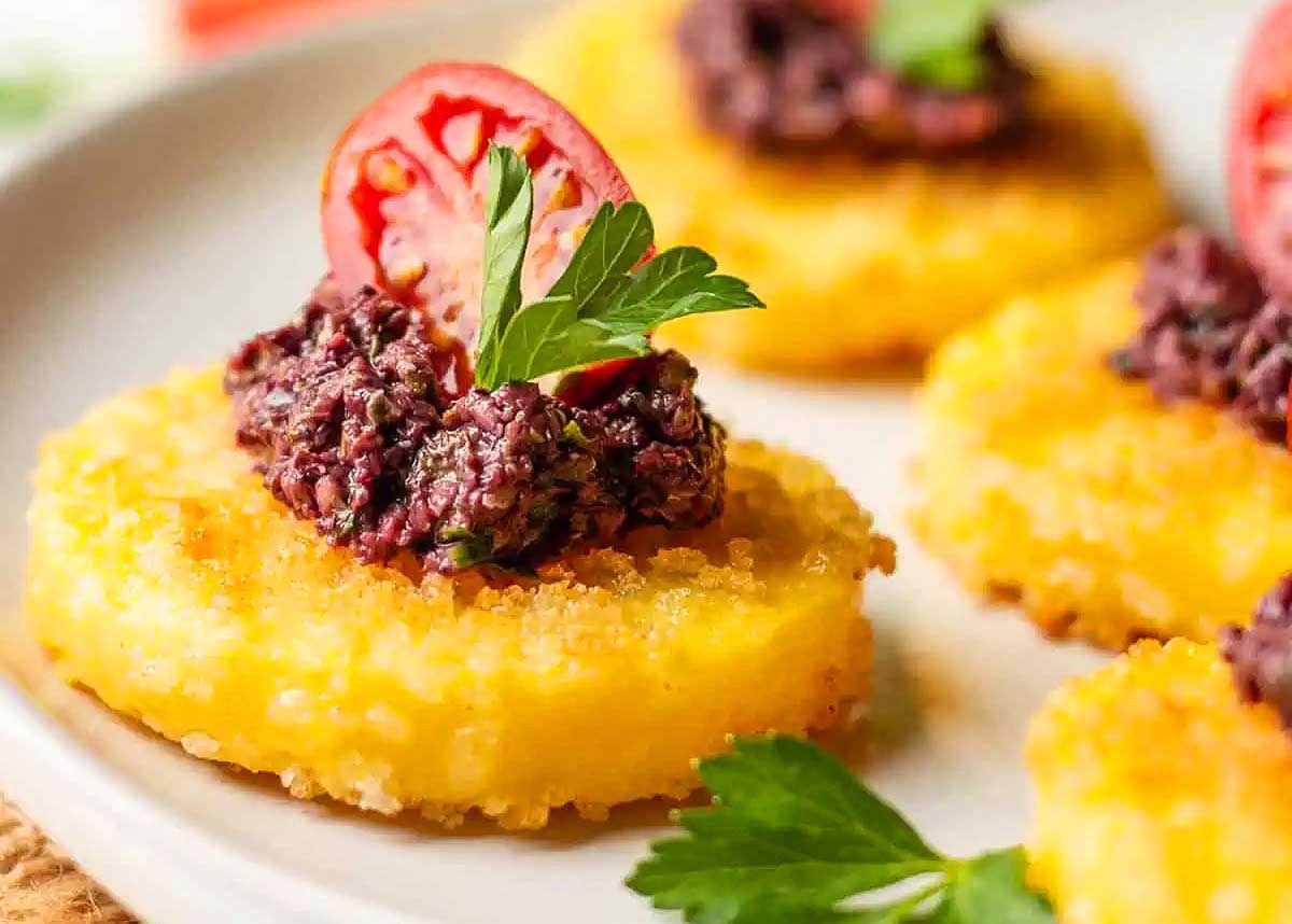Polenta slices topped with olive tapenade.