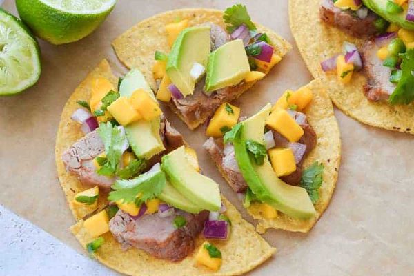 Pork tostados with lime on parchment paper.