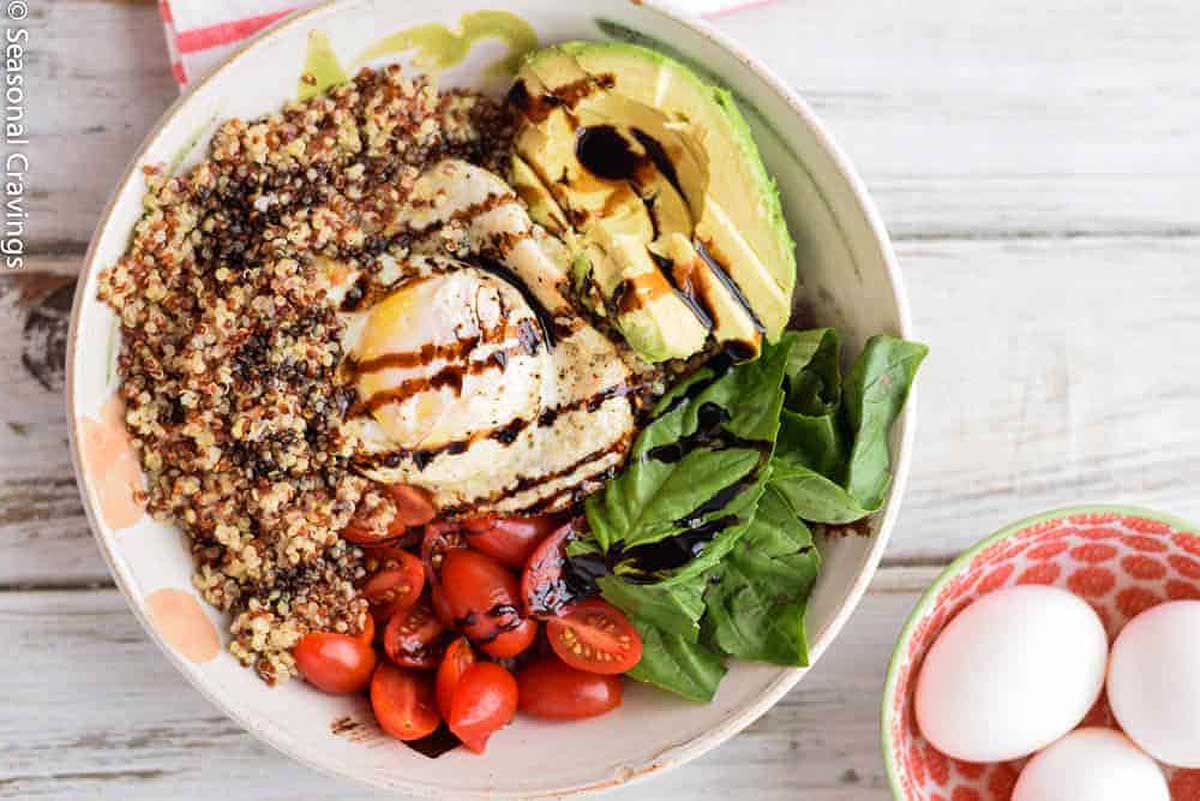 Quinoa, egg, avocado and spinach in a bowl with balsamic dressing.