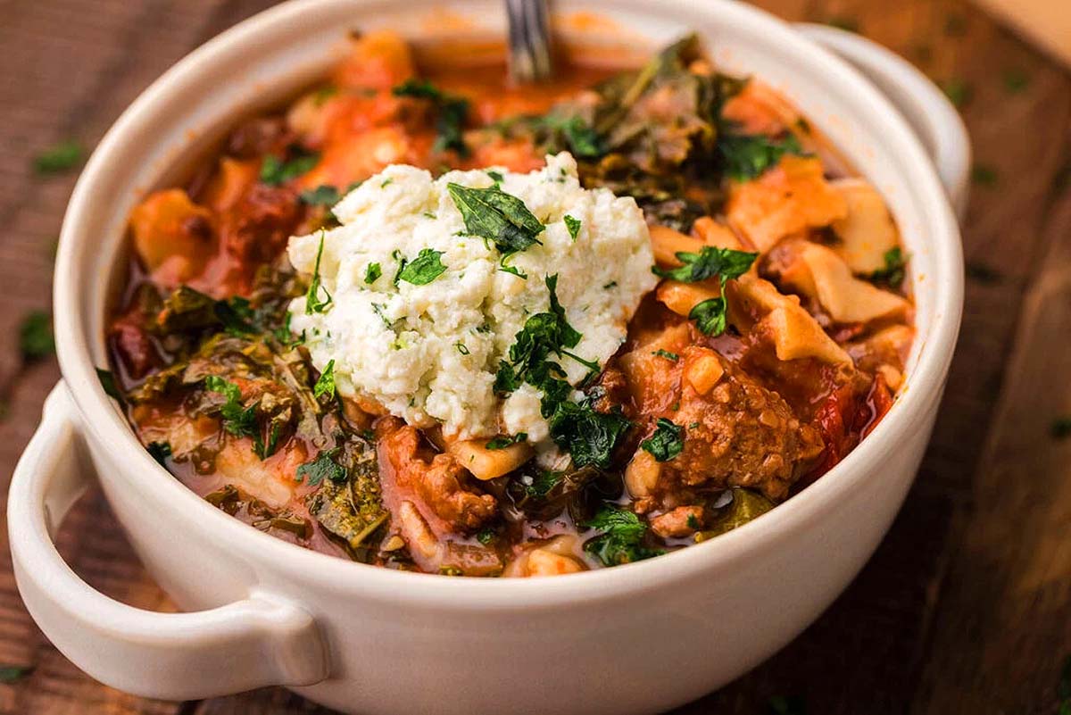 Lasagna soup in a bowl topped in fresh cheese.