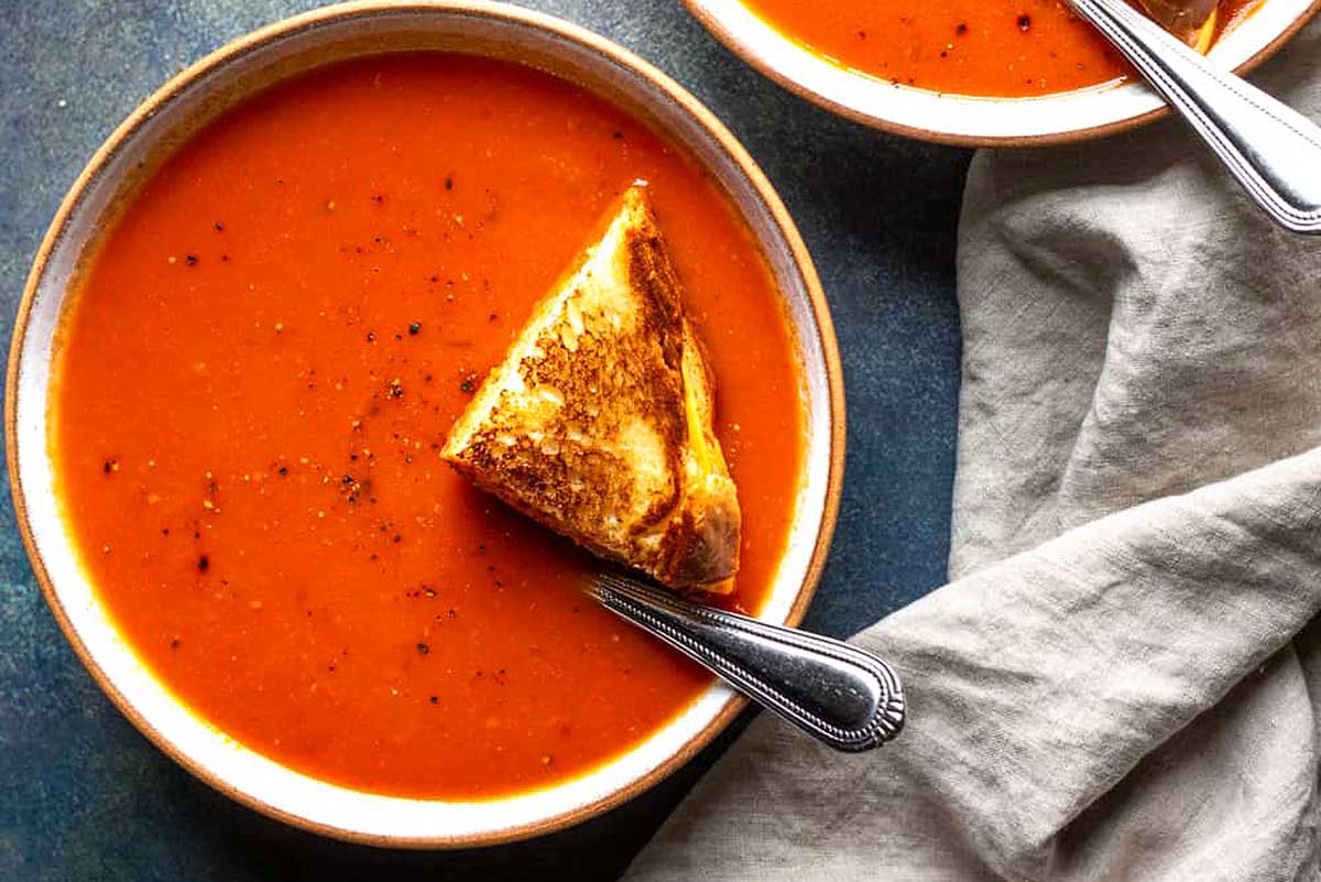 Spicy Tomato Soup with grilled cheese on top.
